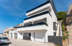 a white house with a car parked in front of it at Lovely Apartment In Drage With Sauna in Drage
