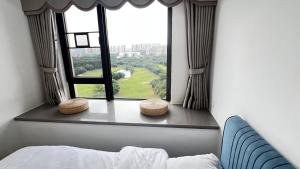 博罗Peicui Apartment的一间卧室设有窗户、一张床和两张凳子