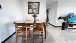 博罗Peicui Apartment的餐桌、椅子和一瓶鲜花