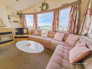 ein Wohnzimmer mit Sofa und Tisch in der Unterkunft Summer Breeze in Perranzabuloe + 14 Fotos