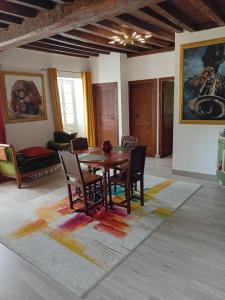 a dining room with a table and chairs on a rug at Chambres Mendiondo Gaü Eztia in Ossas-Suhare