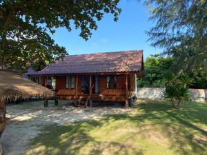 a small wooden house with a thatched roof at Angthong Beach Resort in Koh Phaluai