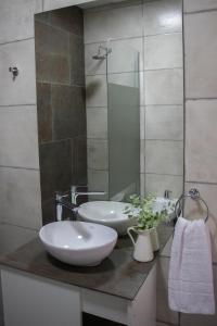 un baño con dos lavabos y un espejo en Las Nencias Houses, en San Carlos 3 fotos más