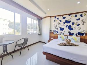 a bedroom with a bed and a table in it at Lanting House Phuket in Patong Beach