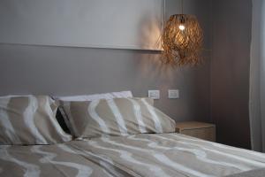 Una cama con sábanas blancas y una lámpara de araña en un dormitorio. en Las Nencias Houses, en San Carlos