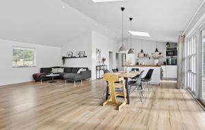a living room and dining room with a table and chairs at 3 Bedroom Nice Home In Vejby in Vejby