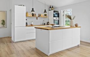 a white kitchen with white cabinets and a counter at 3 Bedroom Nice Home In Vejby in Vejby +17 photos