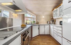 a kitchen with white cabinets and stainless steel appliances at Nice Home In Ebeltoft With Sauna in Ebeltoft