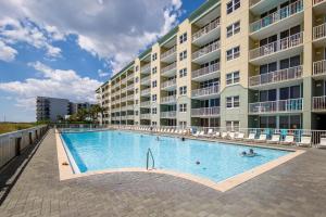a swimming pool in front of a large apartment building at Waters Edge 507 in Fort Walton Beach