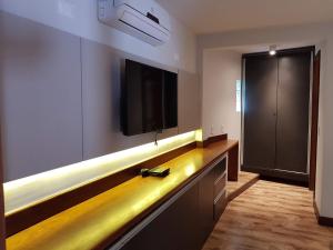 una sala de estar con TV y un centro de entretenimiento largo en Casa Cavalo Marinho - Superconfortável! Perto de tudo, longe do tumulto., en Arraial d'Ajuda