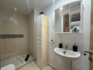 a white bathroom with a sink and a shower at Samsara Beach in Port d'Alcudia