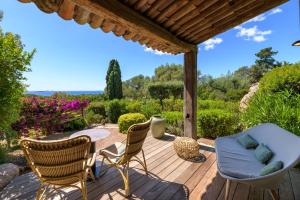 a wooden deck with chairs and a table at Les Bergeries De Palombaggia in Porto-Vecchio