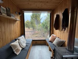 a room with two couches and a large window at Minicasa en Bariloche in San Carlos de Bariloche