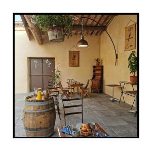 a room with a table and chairs and a barrel at Des Lits Sur La Place in Hérépian