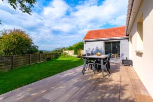 a wooden deck with a table and chairs on a house at L'Ecrin d'Opale, la nature à proximité des sites incontournables in Audembert