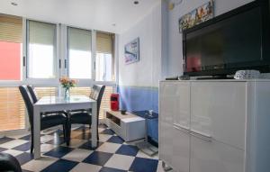 a living room with a table and a flat screen tv at One-Bedroom Apartment In La Pobla De Farnals in Masalfasar