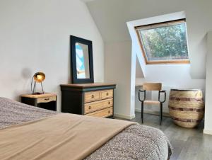 a bedroom with a bed and a dresser and a window at L'Ecrin d'Opale, la nature à proximité des sites incontournables in Audembert