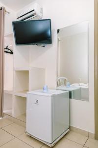 a room with a mirror and a tv on the wall at Hotel Dinamarca in Balneário Camboriú +37 photos