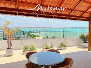 a patio with a table and chairs and a view of the ocean at Manaíra Palace Residence-Prédio Beira Mar in João Pessoa