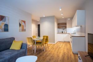 a living room with a couch and a table and chairs at Sosnowy "6", blisko centrum, w otoczeniu lasu in Kielce