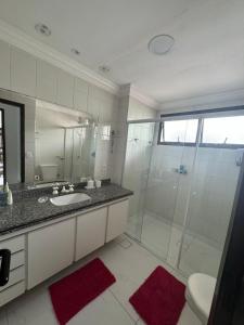 a bathroom with a glass shower and a sink at Excelente Apartamento Proximo A Praia Da Enseada in Guarujá