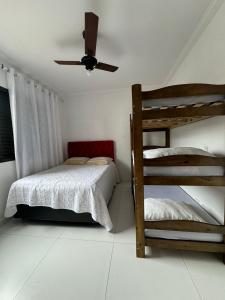 a bedroom with two bunk beds and a ceiling fan at Excelente Apartamento Proximo A Praia Da Enseada in Guarujá
