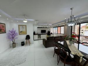 a living room with a couch and a table and chairs at Excelente Apartamento Proximo A Praia Da Enseada in Guarujá