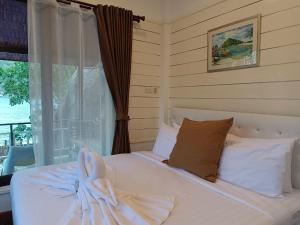 a bedroom with a bed with a towel on it at Nangyuan Island Dive Resort in Ko Tao