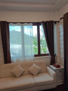 a living room with a couch and a large window at Nangyuan Island Dive Resort in Ko Tao