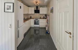 an empty kitchen with white cabinets and a door at 1 Bedroom Amazing Apartment In Vestby in Vestby +2 photos