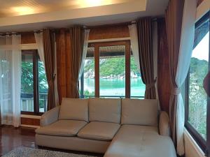 a living room with a couch and large windows at Nangyuan Island Dive Resort in Ko Tao