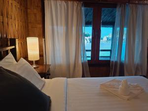 a bedroom with a white bed with a window at Nangyuan Island Dive Resort in Ko Tao