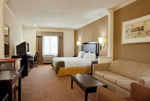 a hotel room with a bed and a couch at ASPEN GRAND HOTEL LaPorte in La Porte