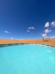 a swimming pool in the middle of a desert at Sahara Majestic Luxury Camp in Merzouga