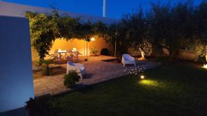 a backyard with a table and chairs in the yard at night at CasaMarè in Taranto