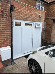 a pair of white garage doors on a brick building at Franky's Place luxury apartment in The Hyde