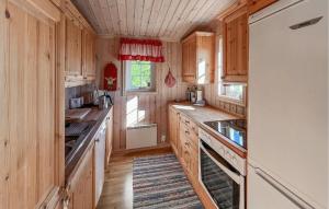 Una cocina con gabinetes de madera y un refrigerador blanco. en Stunning Home In Sjusjøen With Sauna, en Sjusjøen 14 fotos más