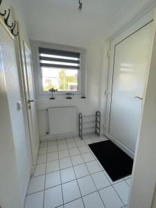 a white hallway with a window and a door at Ferienwohnung Bach in Travemünde in Lübeck