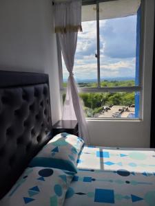 a bedroom with a bed and a large window at Apartamento Armenia, como en casa! in Armenia
