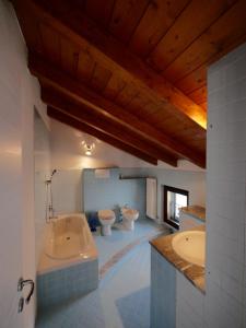 un ampio bagno con due servizi igienici e una vasca di B&B Como Lake Cottage a Lecco