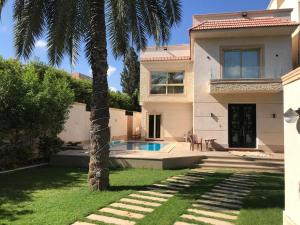 a house with a palm tree in the yard at Happy Villa For Families Only in Alexandria