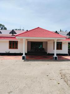 ein weißes Haus mit einem roten Dach in der Unterkunft Hill garden homestay,Vagamon in Vagamon