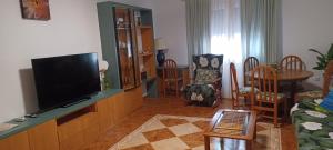 a living room with a flat screen tv and a table at Reina Amalia in Quintanar de la Orden