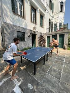 リオデジャネイロにあるCastelo dos Tucanos Hostの卓球台の上で卓球をしている二人