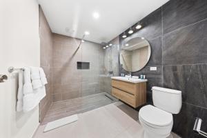 Un baño con inodoro, lavabo y ducha. en Boca Beach House NEW LUX 6 Bed 6 Bath Pool Walk To Beach, en Palm-Eagle Beach