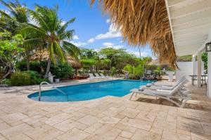una piscina con dos sillas y una palmera en Boca Beach House NEW LUX 6 Bed 6 Bath Pool Walk To Beach, en Palm-Eagle Beach 78 fotos más