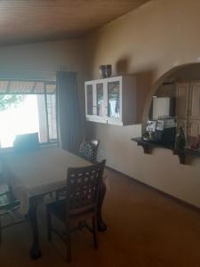 a dining room with a table and a kitchen at Bed on 22 in Ballito
