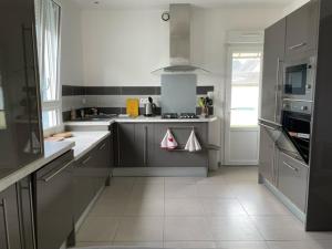 a kitchen with gray counters and a white floor at Les Sables d'or in Agon Coutainville