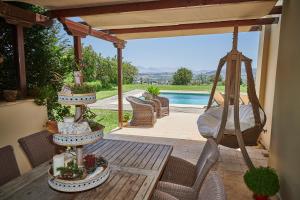 a patio with a hammock and a swing at Luxury Maisonette with Pool in Pallini