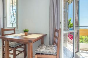 a table and chairs in a room with a balcony at Blue Maraçi 1 Beach Access nd Parking in Himare